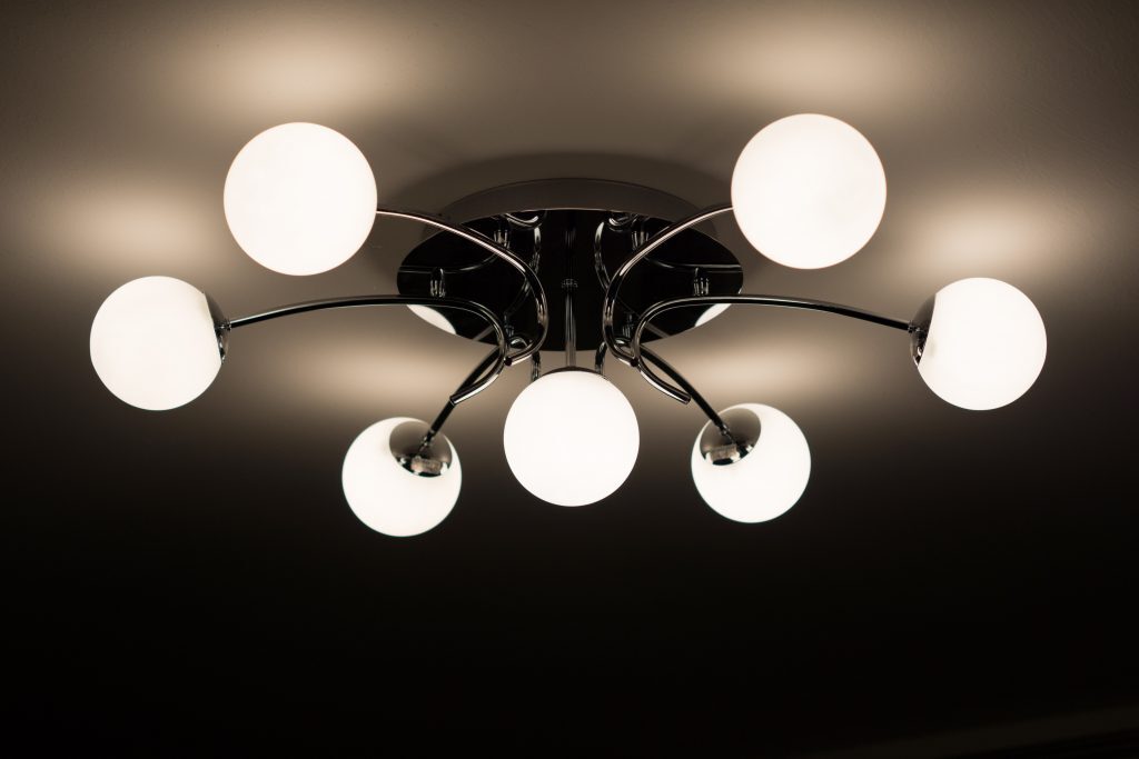 Contemporary ceiling light fixture with multiple white globe bulbs on black metal arms